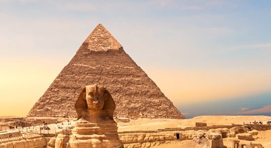 Pyramids and Sphinx under sunset sky