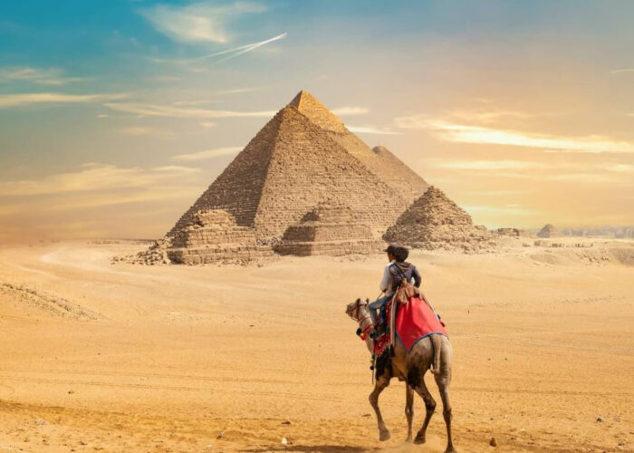 Travelers on a camel before the Great Pyramids