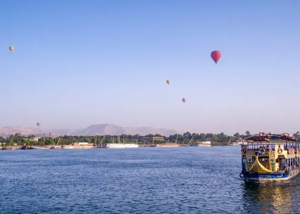 Hot air balloons over river cruise